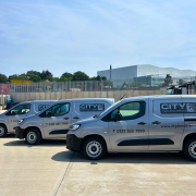 Three vans in a row in the sun showing the City Demolition company